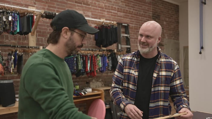 Deux hommes discutent dans un atelier de conception de sous-vêtements pour homme.