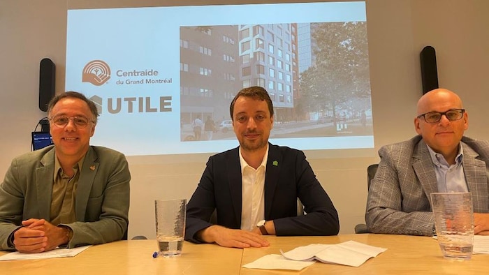 Luc Rabouin, Laurent Levesque et Claude Pinard sourient à la table d'une conférence de presse.