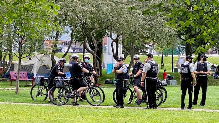 Des hommes en uniforme sur des vélos dans un parc.