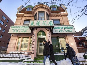 People walk past a home on St-Urbain St. in Montreal’s Chinatown Sunday Jan. 23, 2022. Parts of Chinatown, including this house, will be classified as a heritage district.