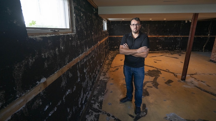 M. Gratton dans le sous-sol de son logement où les revêtements du plancher et des murs ont été complètement arrachés.