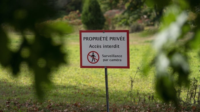Un terrain sur lequel est placé une pancarte indiquant qu'il s'agit d'une propriété privée.