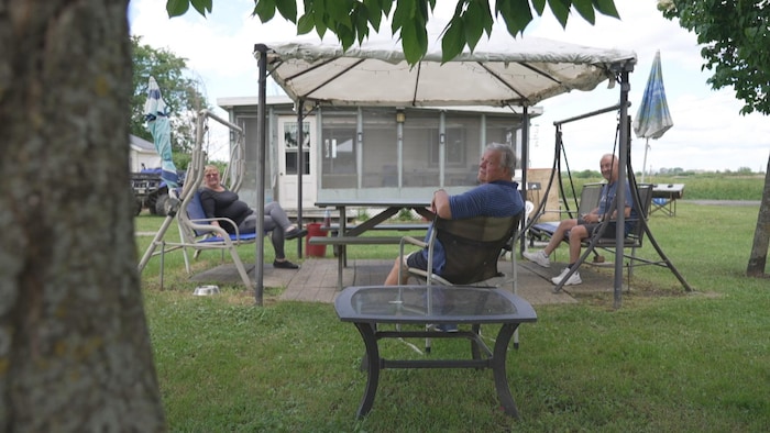 Trois résidents de l'île Sainte-Thérèse sont assis.