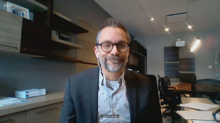 Un homme portant des lunettes en entrevue en visioconférence dans son bureau