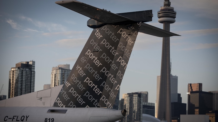 Un avion stationné sur le tarmac de l'aéroport des îles devant le centre-ville de Toronto.
