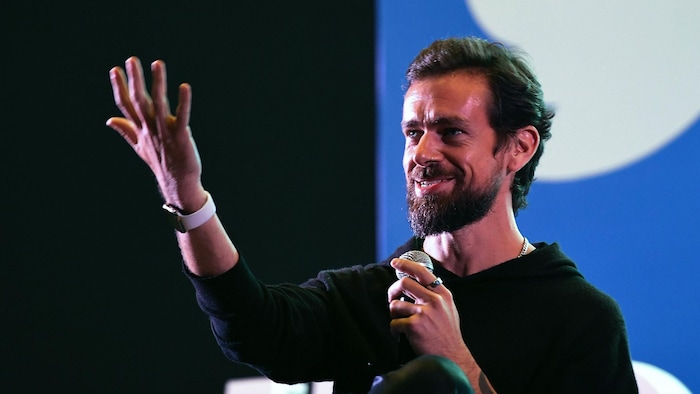 Jack Dorsey parle sur scène en tenant un micro pendant une conférence.