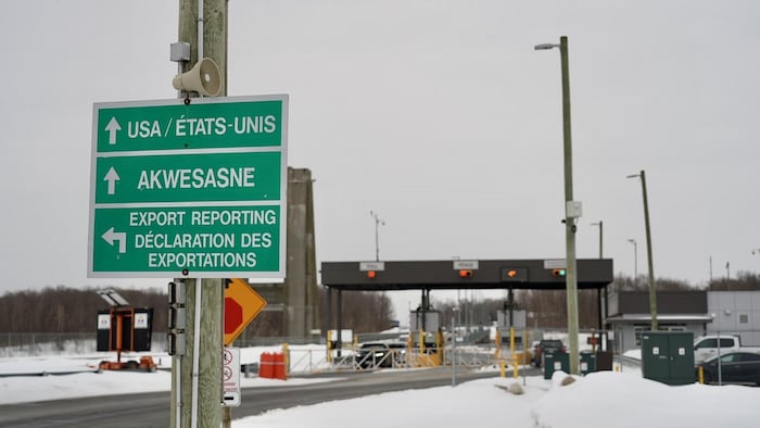 Un panneau devant un poste-frontière indiquant «USA/États-Unis, Akwesasne, Export reporting/Déclaration des exportations».