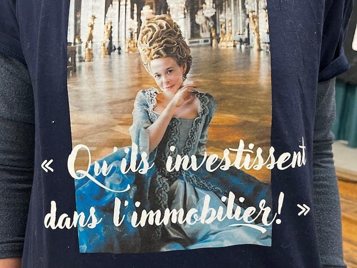 Un chandail porte une image de la ministre Duranceau affublée en Marie-Antoinette ainsi que la phrase « Qu'ils investissent dans l'immobilier! ».