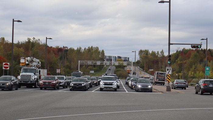 Des voitures attendent à un feu route à l'intersection des boulevards Robert-Bourassa et Lebourgneuf.