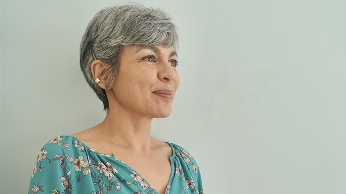 Portrait de la femme aux cheveux gris. Elle sourit.