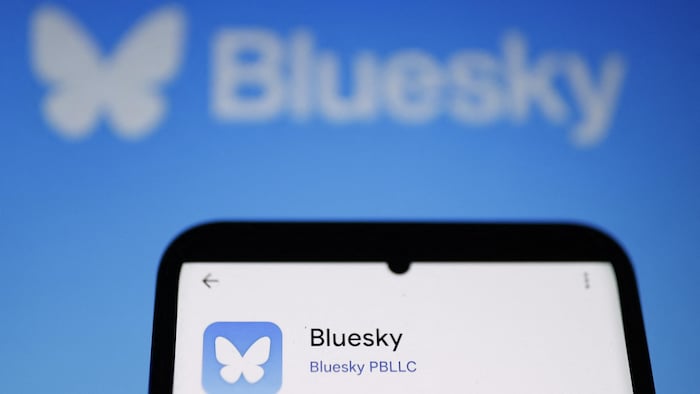 Le haut d'un téléphone intelligent montrant le logo papillon de Bluesky.