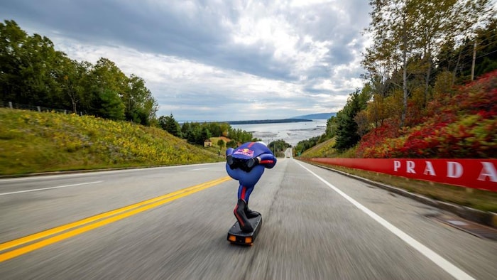 Un homme descend à toute vitesse sur une planche à roulettes.