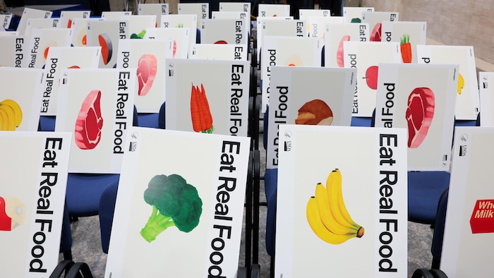 Différents aliments sont dessinés sur des panneaux, sur lesquels il est inscrit : « Mangez de la vraie nourriture ».