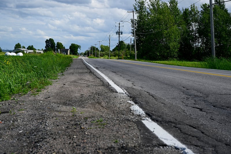 Sans accotement et avec seulement une bande de gravier et de roches sur le côté, les cyclistes doivent prendre leur place dans la voie de circulation de la route de l'Aéroport.|800x533.1999999999999